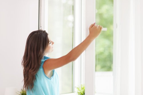 A woman opening a window.