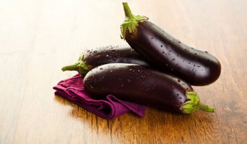A picture of 3 eggplants.