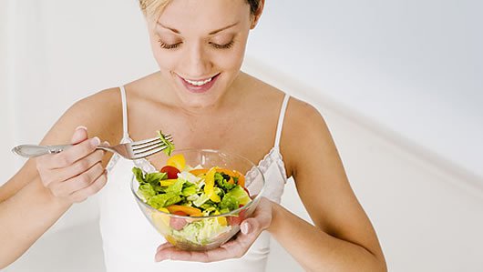 Woman eating a salad trying to eat healthily