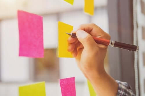 A person writing on post-its.