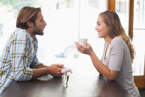 Two people talking and having coffee.