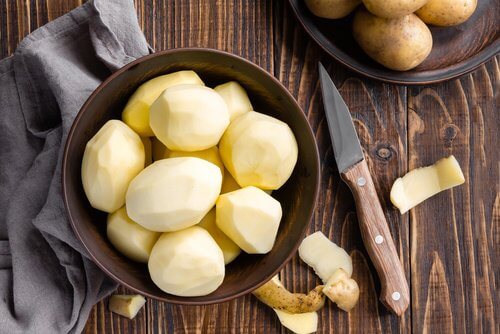 Peeling potatoes to make potato juice for healthier hair