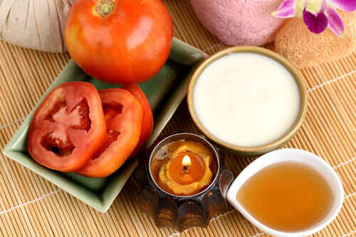 Bowls with milk, honey and tomatoes on a table