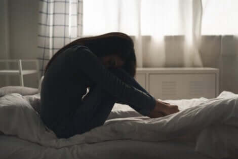 A girl with her head on her knees.