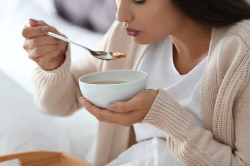 A woman eating some soup.