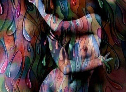 A naked woman covering herself with her arms and she is wrapped in many different colors and patterns