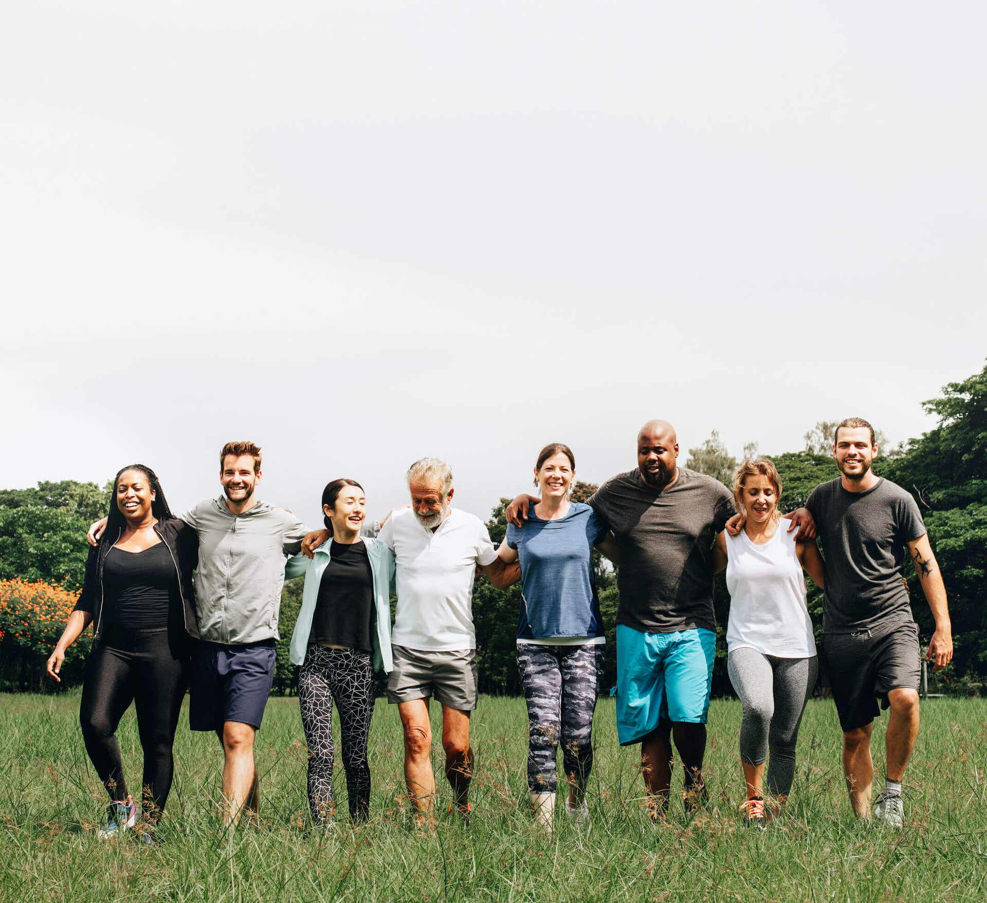 Friends walking with their arms around one another.