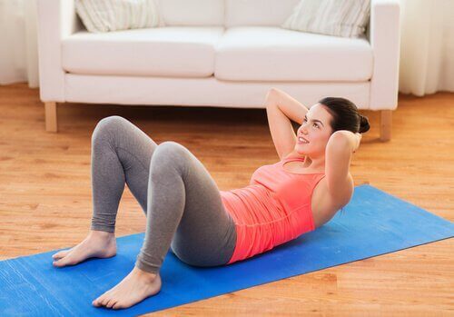 Woman doing crunches on yoga mat lose belly fat