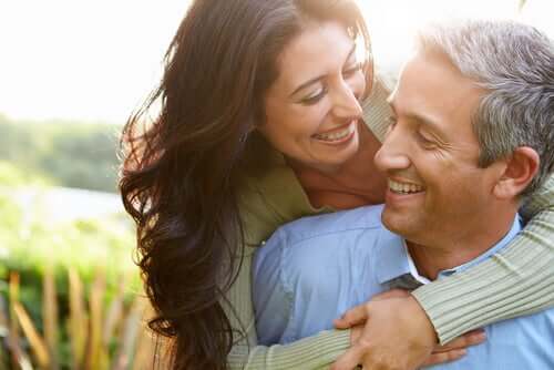 A couple hugging each other and smiling.