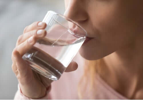 A woman drinking a glass of water.