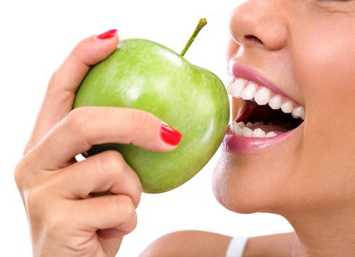 Woman smiling eating green apple anti-aging apple mask