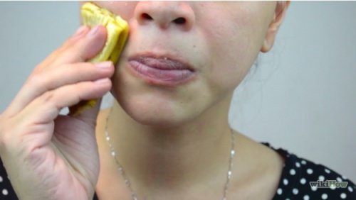 woman using a banana peel on her face
