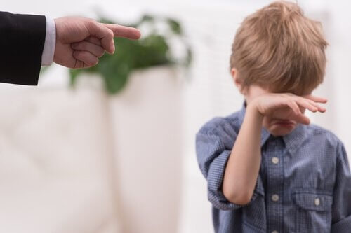 boy crying with dad pointing finger at him, parenting