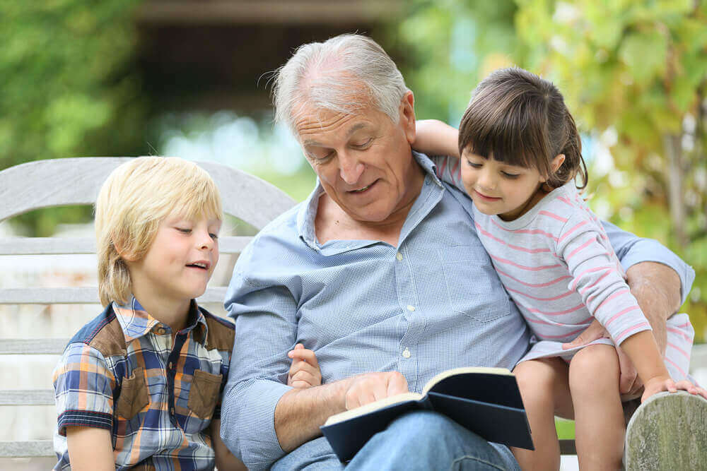 A grandfather reading to his grandchildren.