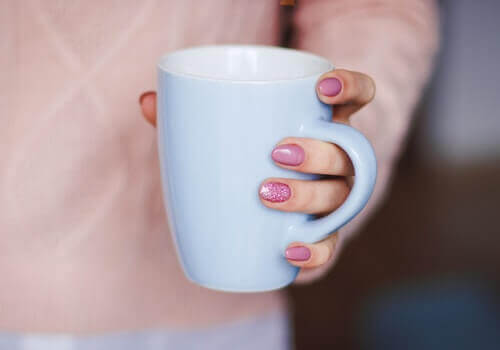A woman holding a cup of tea.