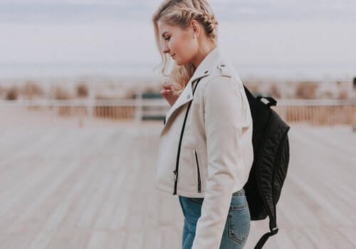 A woman walking with a backpack.