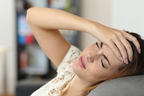 Woman with headache warning signs of fibromyalgia