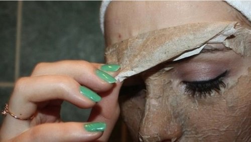 Woman peeling off a mask