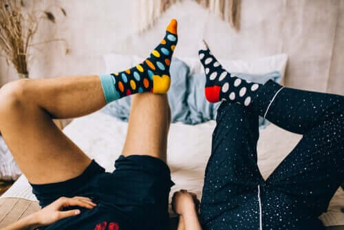 A couple wearing socks in bed.