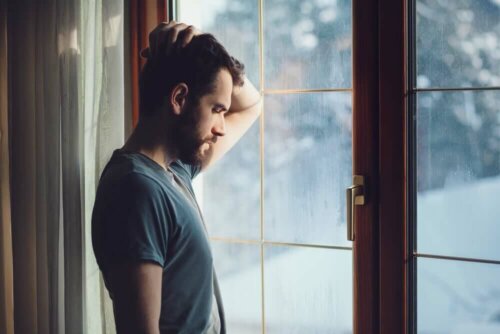 Mangelnde Selbstliebe - verzweifelter Mann am Fenster
