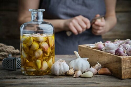 A person putting garlic in a jar with olive oil to help their vision loss.