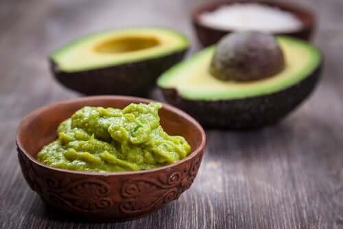 An avocado and a bowl of guacamole.