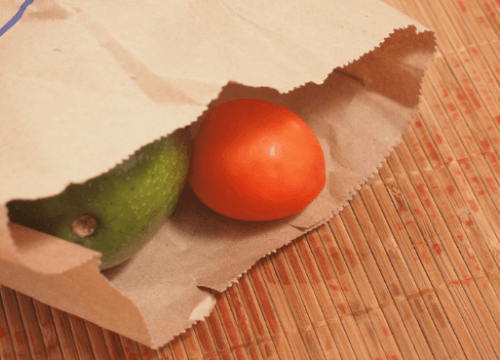 A couple pieces of fruit inside a paper bag.