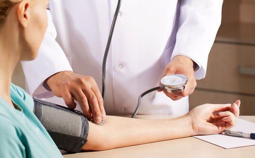 A doctor taking a woman's blood pressure.