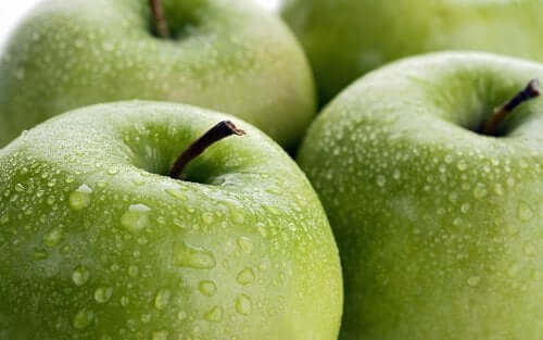 Some green apples with drops of water.