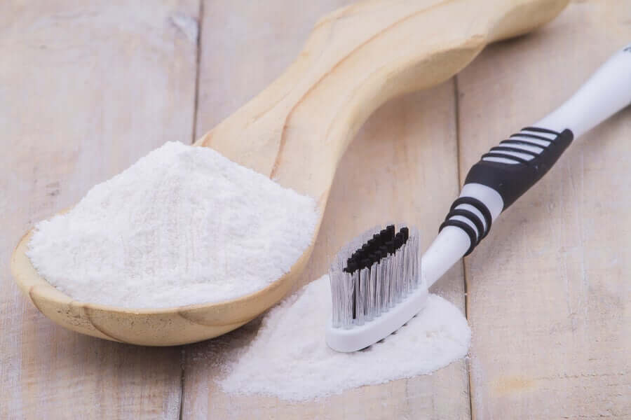 A toothbrush and a spoonful of baking soda, one of the remedies for removing plaque.