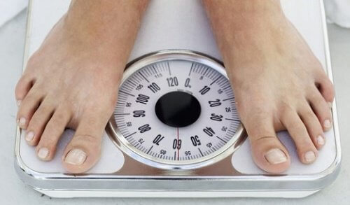 Person on scale stay up late and gain weight