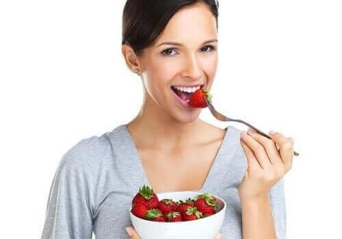 A woman eating strawberries.