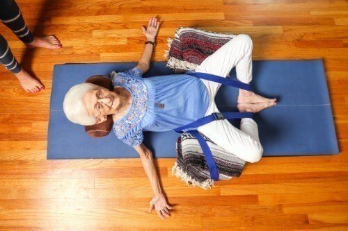 An elderly woman training in yoga.