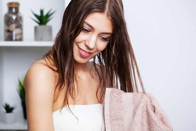 En kvinne som tørker håret med et håndkle.