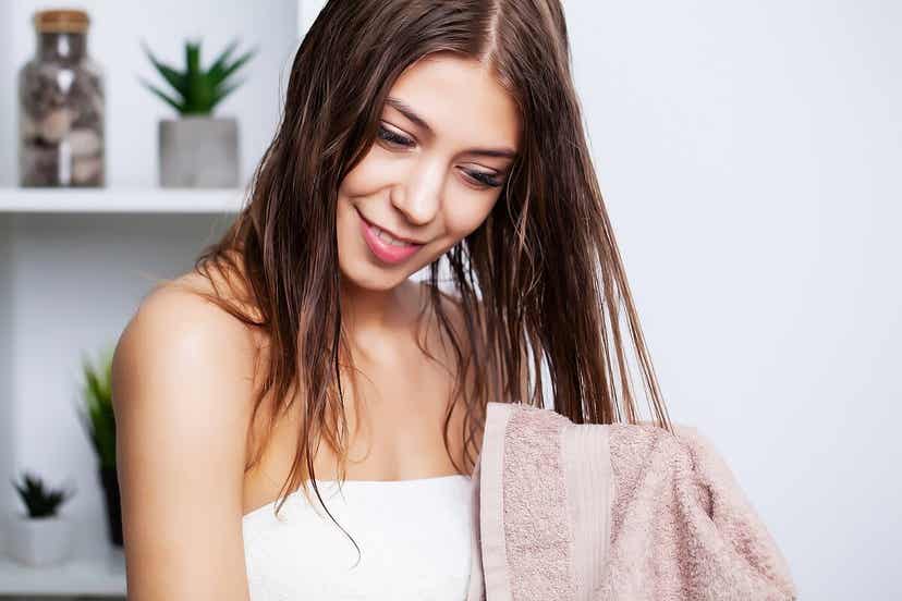 A woman drying her hair with a towel.