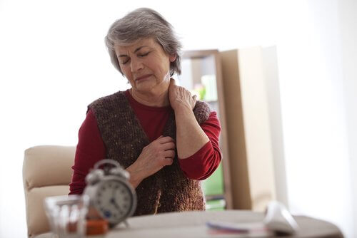 Elderly woman touching her neck to relieve neck pain.