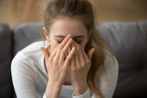 A stressed out woman sitting on a couch.
