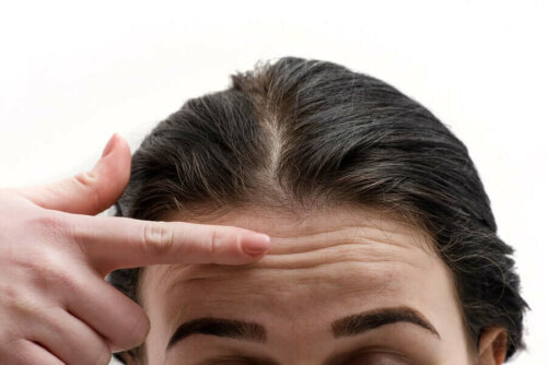 A woman pointing at her forehead.