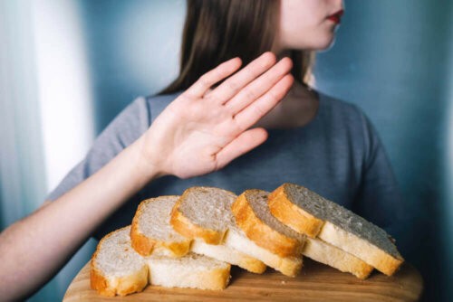 A woman rejecting some bread due to gluten intolerance and pimples on the upper arms.