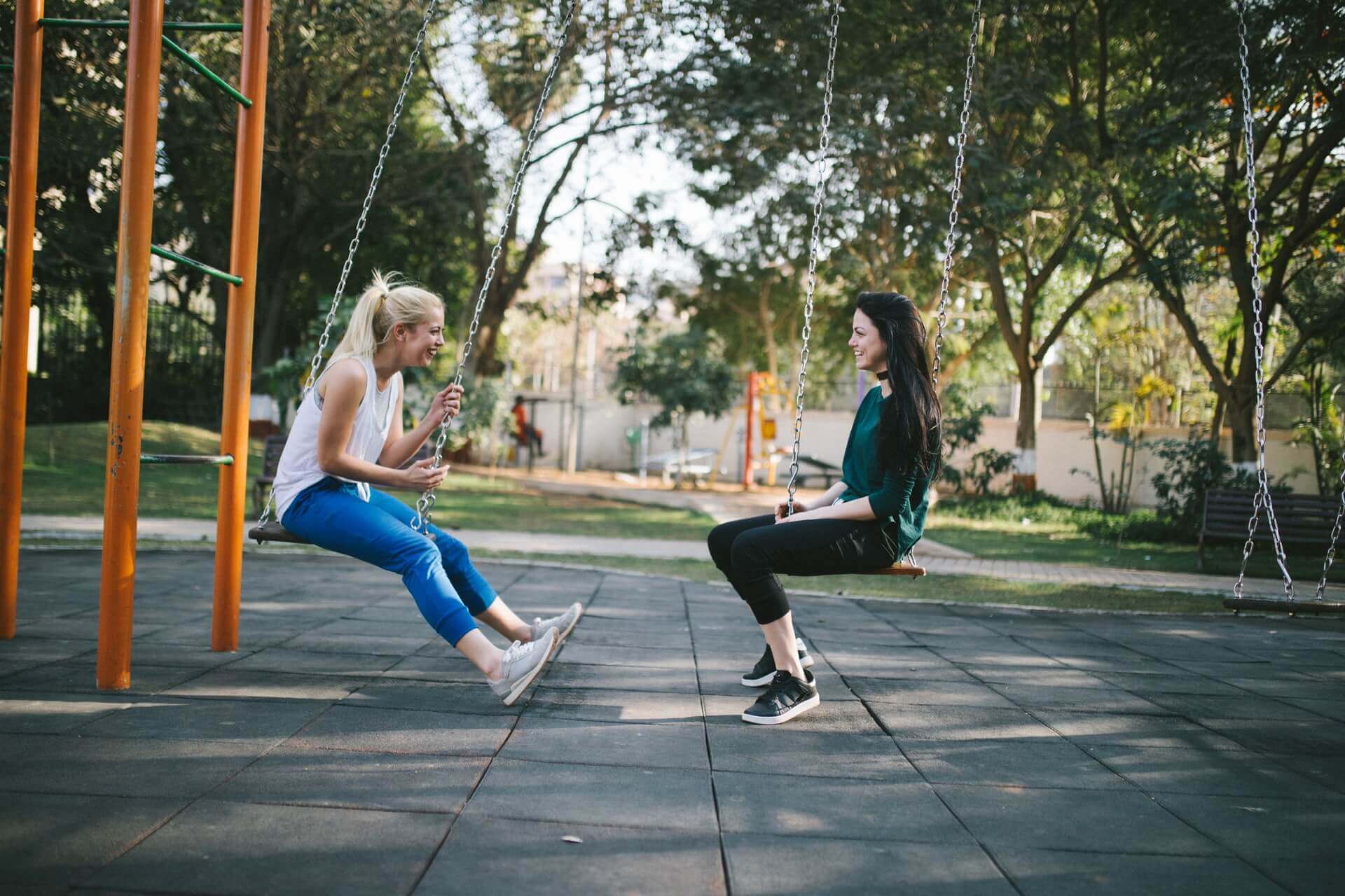Two friends on swings.
