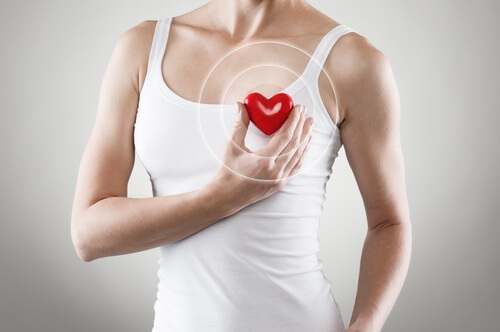 Woman holding a plastic heart to her chest