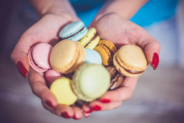Girl-holding-colorful-French-macaroons-in-hands