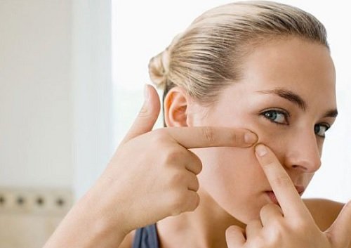 Person popping a pimple.