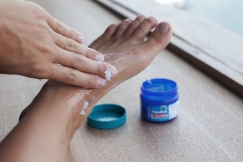 Person applying vicks on their foot uses for vicks vaporub