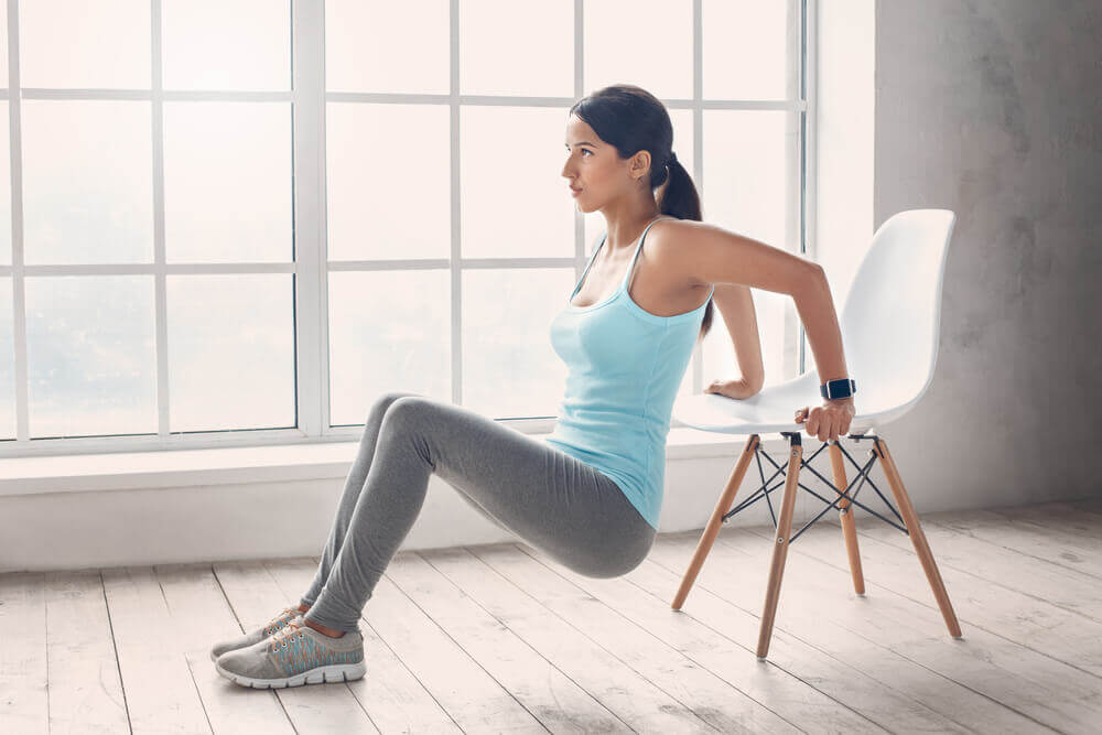 A woman doing Kegel exercises with a chair.