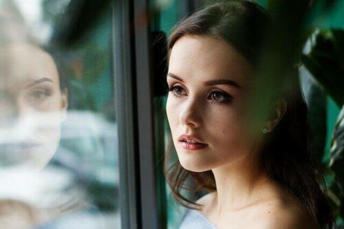 woman looking out of the window sad
