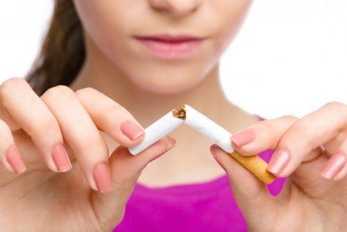 A lady breaking a cigarette.