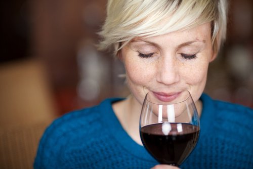 A woman drinking red wine.