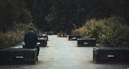 A man sadly sitting on a bench.