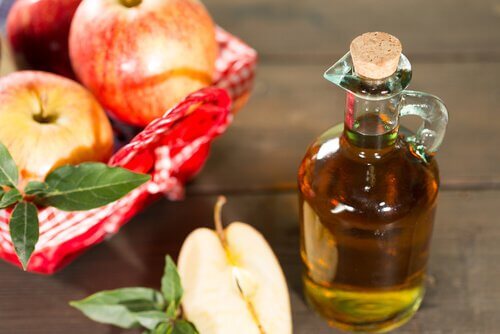 Apple cider vinegar in a jar and a basket of apples
